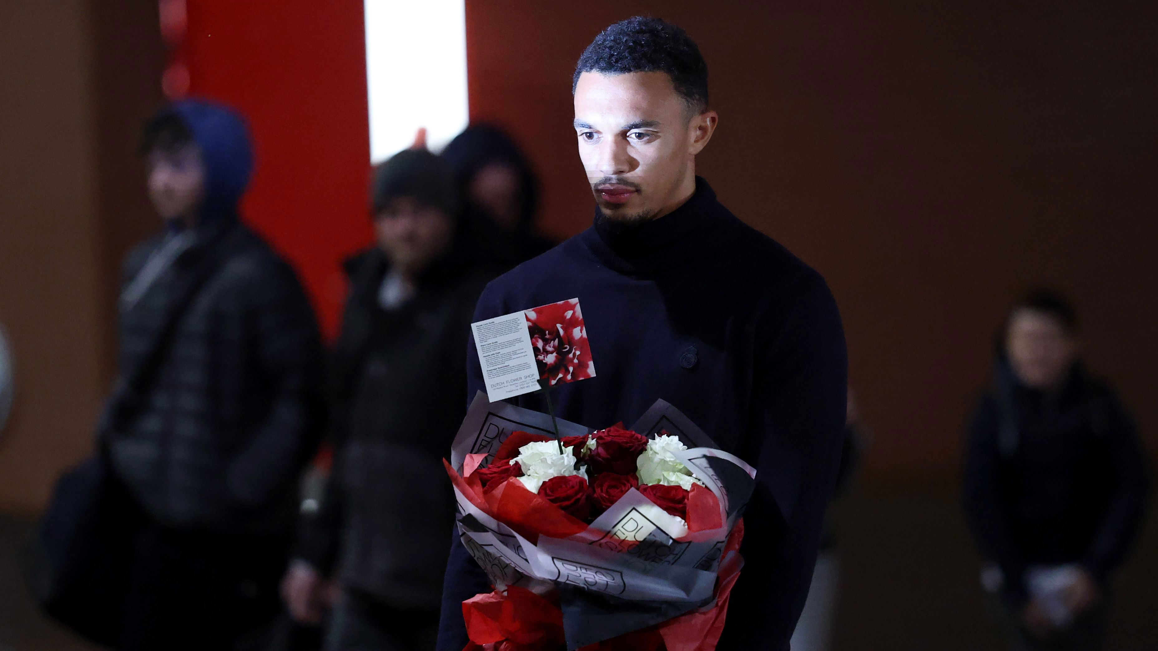 Trent Alexander-Arnold visiting the Diogo Jota memorial at Anfield and placing flowers.
